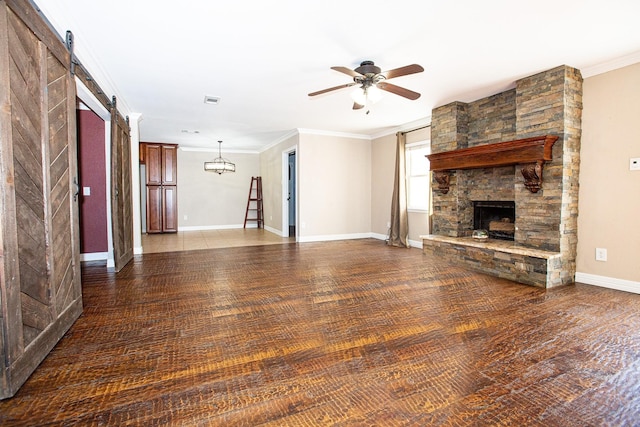 550 Briarwood Dr, Southlake, TX 76092 - unfurnished living room with a barn door, a ceiling fan, wood finished floors, a stone fireplace, and crown molding
