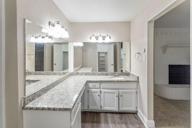 6708 Fair Meadows Dr, North Richland Hills, TX 76182 - bathroom featuring vanity, wood finished floors, and a brick fireplace