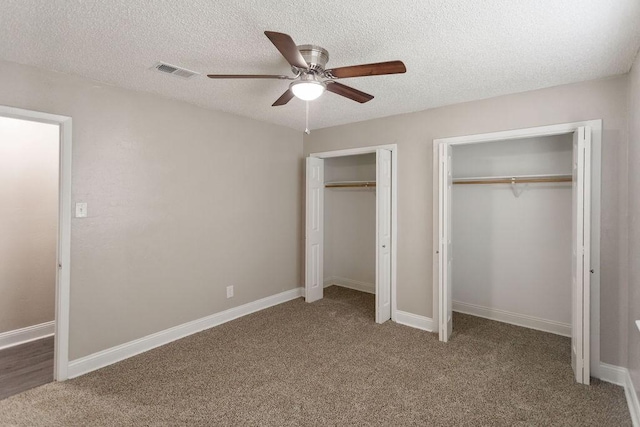 6708 Fair Meadows Dr, North Richland Hills, TX 76182 - unfurnished bedroom featuring multiple closets, carpet floors, a textured ceiling, and a ceiling fan