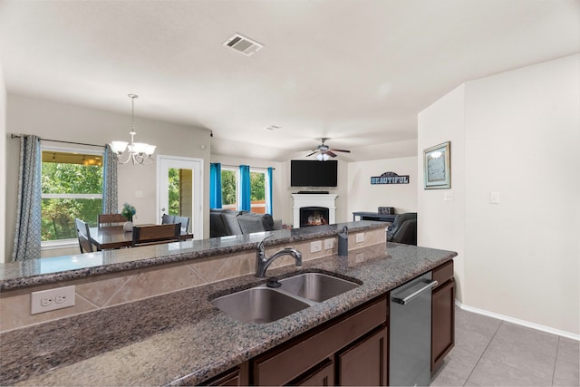 1104 Cheyenne Dr, Aubrey, TX 76227 - kitchen featuring a fireplace, ceiling fan, light tile patterned floors, dark stone counters, and a chandelier