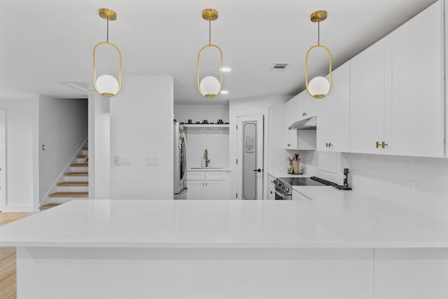2304 Spanish Trl, Irving, TX 75060 - kitchen with under cabinet range hood, stainless steel appliances, white cabinets, and light countertops