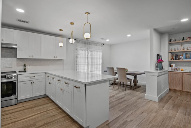 2304 Spanish Trl, Irving, TX 75060 - kitchen with stainless steel electric range oven, a peninsula, exhaust hood, light countertops, and light wood finished floors