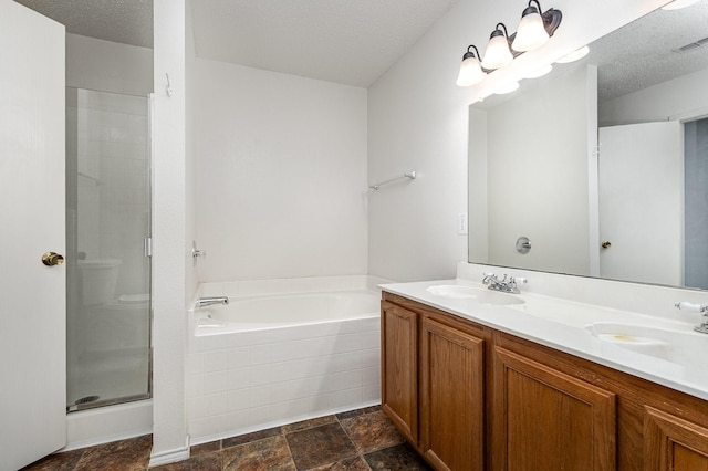 1428 Nimitz Way, Mesquite, TX 75181 - bathroom featuring a bath, a stall shower, double vanity, a textured ceiling, and stone finish flooring