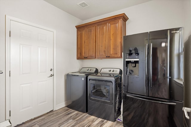 2030 Hills Ct, Stephenville, TX 76401 - laundry room featuring separate washer and dryer, wood finished floors, and cabinet space