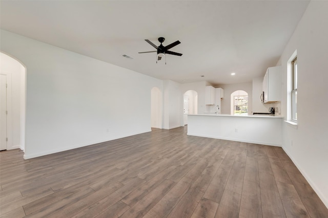 13625 Musselshell Dr, Ponder, TX 76259 - unfurnished living room featuring arched walkways, a ceiling fan, wood finished floors, and recessed lighting