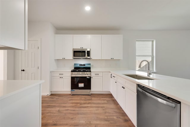 13625 Musselshell Dr, Ponder, TX 76259 - kitchen with appliances with stainless steel finishes, white cabinetry, light wood-style flooring, light countertops, and recessed lighting