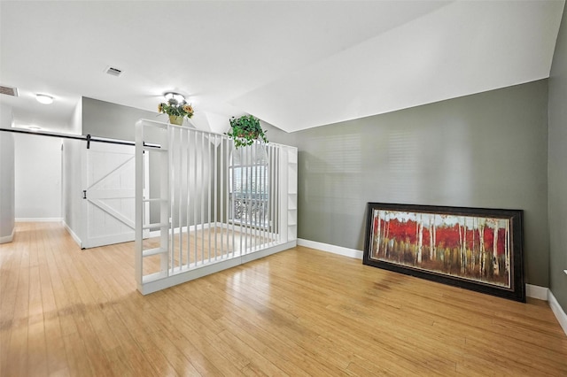 4917 Summer Oaks Ln, Fort Worth, TX 76123 - unfurnished living room with light wood-type flooring, a barn door, and lofted ceiling