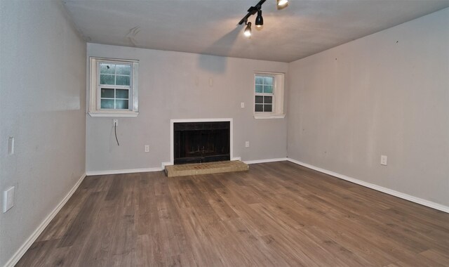 4300 Hidden Creek Dr, Arlington, TX 76016 - unfurnished living room featuring wood finished floors, a fireplace with raised hearth, and plenty of natural light