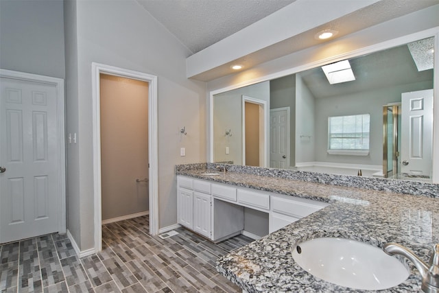 4300 Hidden Creek Dr, Arlington, TX 76016 - bathroom with lofted ceiling, double vanity, a skylight, and wood finished floors