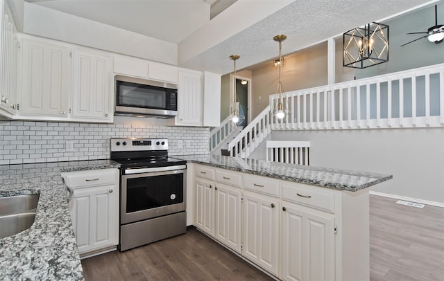 4300 Hidden Creek Dr, Arlington, TX 76016 - kitchen with appliances with stainless steel finishes, a peninsula, dark wood-style floors, and decorative backsplash