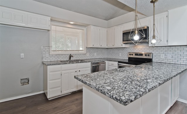 4300 Hidden Creek Dr, Arlington, TX 76016 - kitchen with appliances with stainless steel finishes, a peninsula, tasteful backsplash, dark stone countertops, and white cabinets