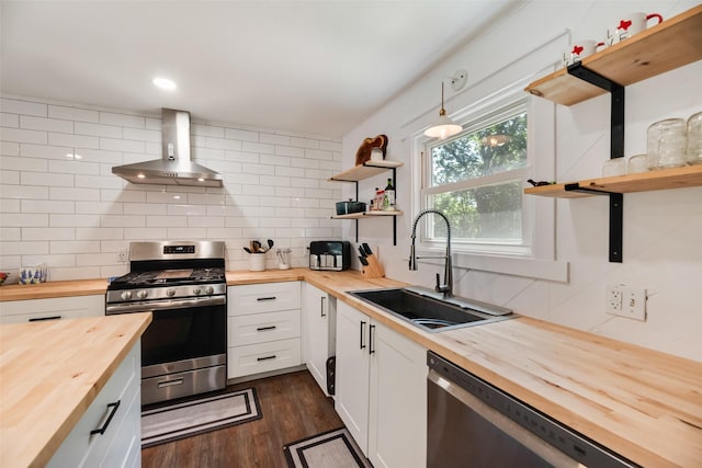 206 E Park, Italy, TX 76651 - kitchen with butcher block countertops, open shelves, stainless steel appliances, wall chimney exhaust hood, and tasteful backsplash