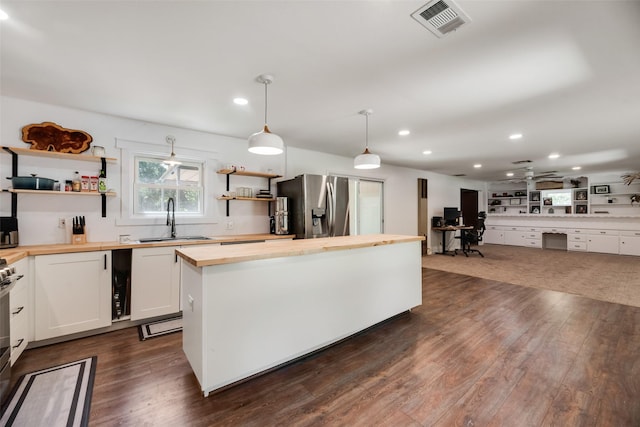 206 E Park, Italy, TX 76651 - kitchen with butcher block counters, appliances with stainless steel finishes, open shelves, dark wood finished floors, and a kitchen island