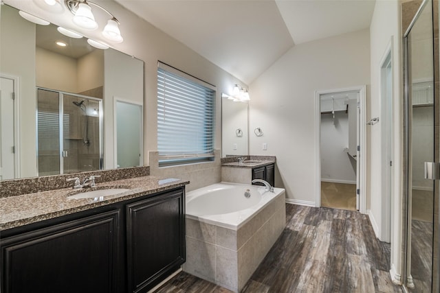1304 Meridian Dr, Forney, TX 75126 - bathroom featuring a stall shower, lofted ceiling, two vanities, a spacious closet, and wood finished floors
