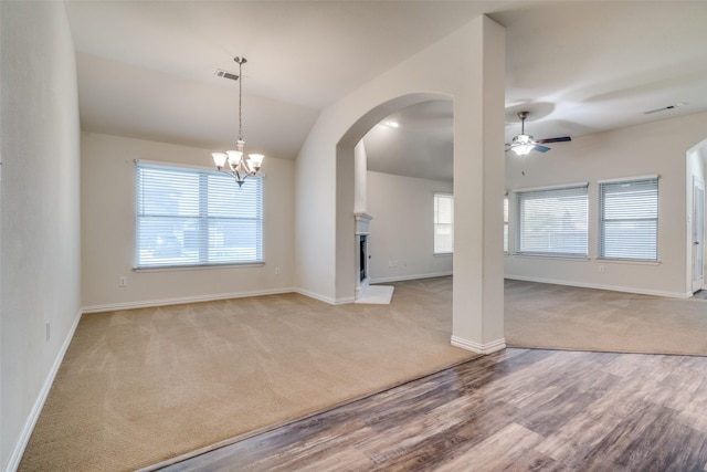 1304 Meridian Dr, Forney, TX 75126 - empty room with ceiling fan, arched walkways, carpet floors, wood finished floors, and vaulted ceiling