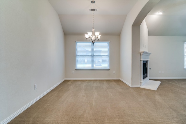 1304 Meridian Dr, Forney, TX 75126 - unfurnished dining area with carpet flooring, a chandelier, arched walkways, lofted ceiling, and a fireplace with raised hearth