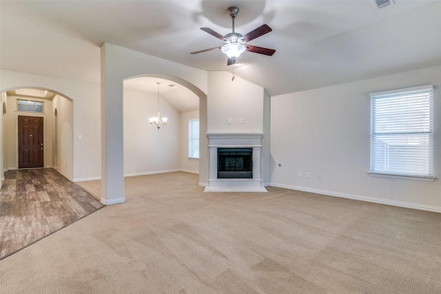 1304 Meridian Dr, Forney, TX 75126 - unfurnished living room with vaulted ceiling, arched walkways, carpet flooring, ceiling fan, and a fireplace with raised hearth