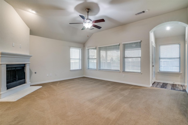 1304 Meridian Dr, Forney, TX 75126 - unfurnished living room featuring a ceiling fan, carpet floors, arched walkways, a fireplace with raised hearth, and lofted ceiling