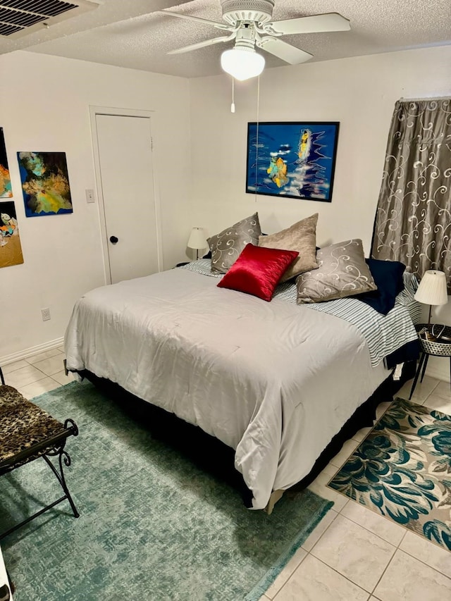 5611 Harvest Hill Rd Unit 1012, Dallas, TX 75230 - bedroom with tile patterned floors, ceiling fan, and a textured ceiling