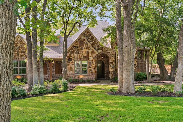 105 Blue Sage Ct, Weatherford, TX 76087 - english style home with stone siding, a front yard, a shingled roof, and brick siding