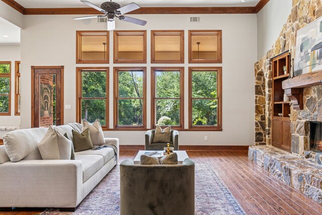 105 Blue Sage Ct, Weatherford, TX 76087 - living room featuring ornamental molding, wood finished floors, a stone fireplace, and a ceiling fan