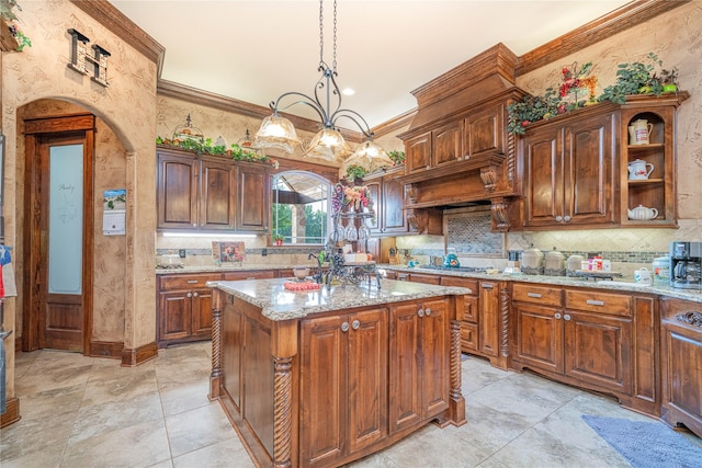 4555 Farm Rd Unit 1402, Mount Pleasant, TX 75455 - kitchen featuring decorative backsplash, light stone countertops, crown molding, a kitchen island, and a chandelier