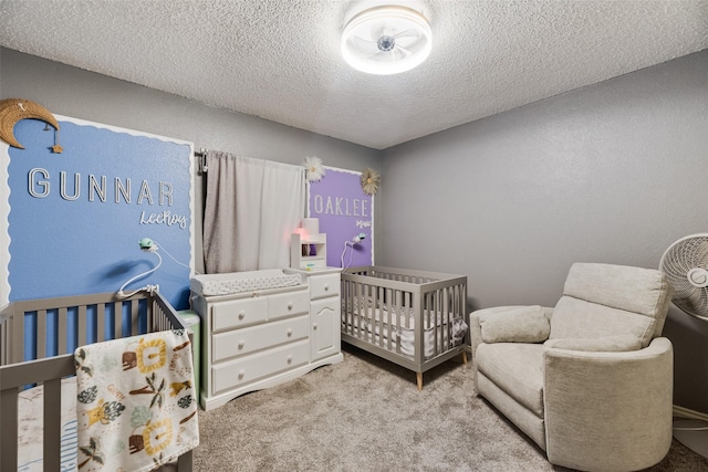 3302 Oxford Dr, Rowlett, TX 75088 - bedroom featuring a crib, a textured ceiling, and light colored carpet