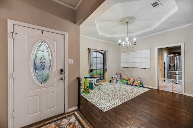 3302 Oxford Dr, Rowlett, TX 75088 - entryway with wood finished floors, a raised ceiling, a chandelier, and crown molding