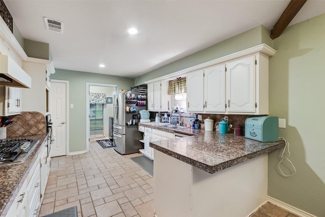 3302 Oxford Dr, Rowlett, TX 75088 - kitchen with appliances with stainless steel finishes, tasteful backsplash, a peninsula, white cabinets, and recessed lighting