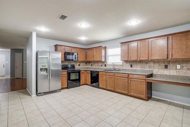 1347 Hillside Dr, Burleson, TX 76028 - kitchen with black appliances, tasteful backsplash, brown cabinets, light tile patterned floors, and recessed lighting
