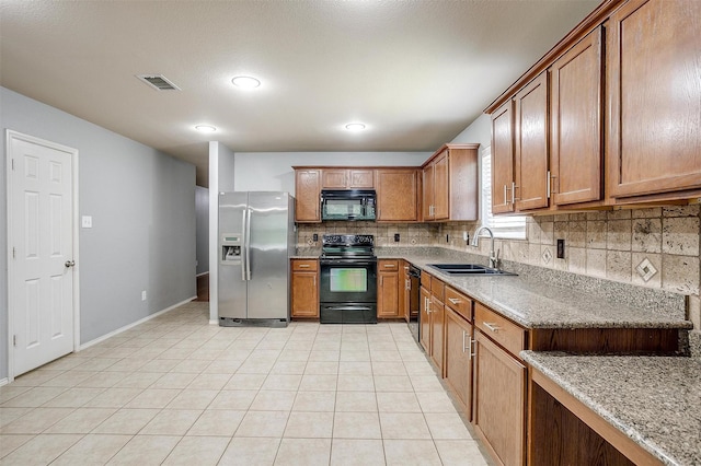 1347 Hillside Dr, Burleson, TX 76028 - kitchen featuring black appliances, decorative backsplash, brown cabinets, light stone countertops, and light tile patterned flooring