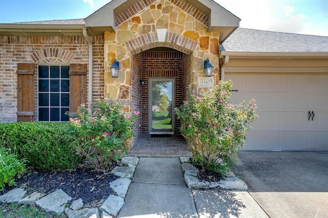 1347 Hillside Dr, Burleson, TX 76028 - property entrance with stone siding, a garage, a shingled roof, and brick siding