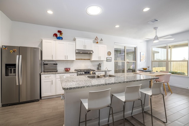 9657 Alderleaf Trl, Fort Worth, TX 76036 - kitchen with stainless steel appliances, light wood finished floors, white cabinetry, decorative backsplash, and recessed lighting