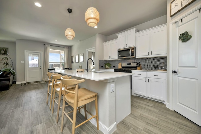 2305 Waggoner Ranch Dr, Weatherford, TX 76087 - kitchen with stainless steel appliances, tasteful backsplash, a center island with sink, light countertops, and white cabinets