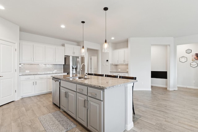 1000 Napier Way, Fort Worth, TX 76247 - kitchen featuring stainless steel appliances, white cabinets, light wood-style floors, gray cabinets, and recessed lighting
