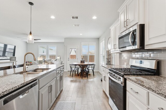 1000 Napier Way, Fort Worth, TX 76247 - kitchen with appliances with stainless steel finishes, light wood-type flooring, decorative backsplash, recessed lighting, and light stone counters