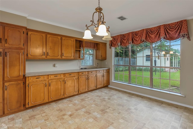 189 India Dr, Shreveport, LA 71115 - kitchen with light countertops, brick patterned flooring, brown cabinetry, a chandelier, and ornamental molding