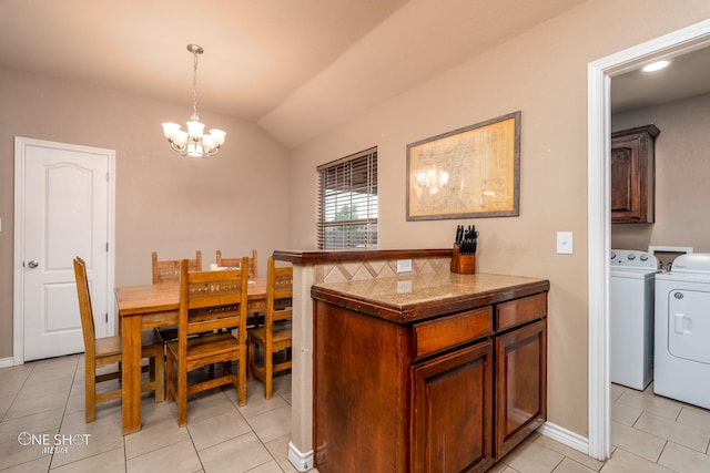217 Sugarloaf Ave, Abilene, TX 79602 - dining area with washing machine and dryer, a chandelier, light tile patterned flooring, and vaulted ceiling