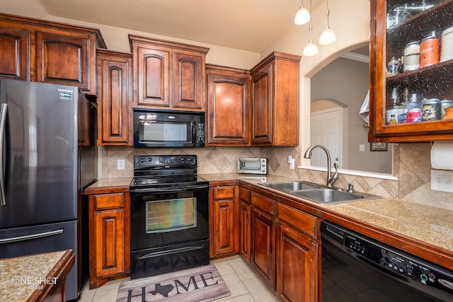 217 Sugarloaf Ave, Abilene, TX 79602 - kitchen with black appliances, arched walkways, backsplash, light tile patterned floors, and hanging light fixtures