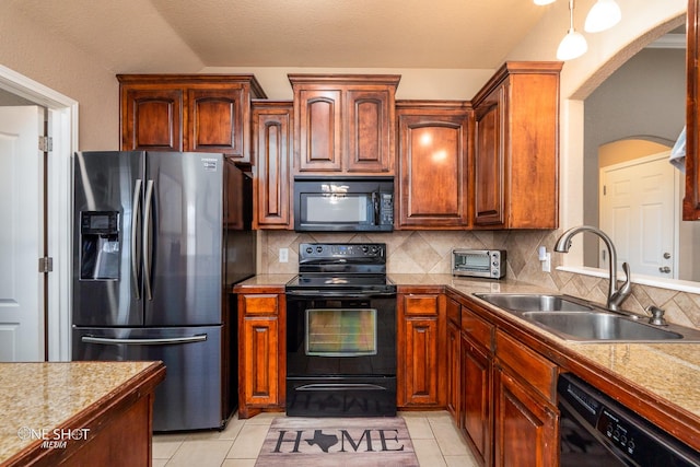 217 Sugarloaf Ave, Abilene, TX 79602 - kitchen with black appliances, arched walkways, tasteful backsplash, and light tile patterned flooring