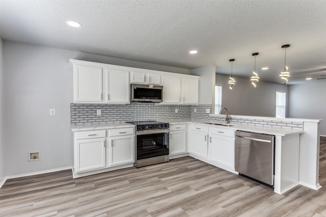 8732 Hunters Trl, Fort Worth, TX 76123 - kitchen featuring stainless steel appliances, a peninsula, light wood-style flooring, tasteful backsplash, and light countertops