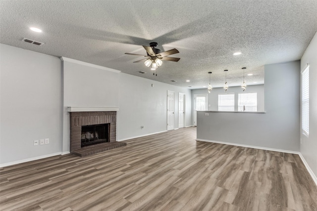 8732 Hunters Trl, Fort Worth, TX 76123 - unfurnished living room with ceiling fan, wood finished floors, recessed lighting, a textured ceiling, and a brick fireplace