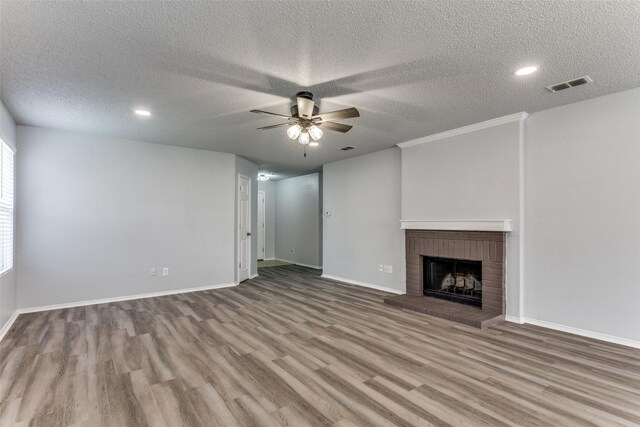 8732 Hunters Trl, Fort Worth, TX 76123 - unfurnished living room featuring wood finished floors, ceiling fan, a textured ceiling, a fireplace, and recessed lighting
