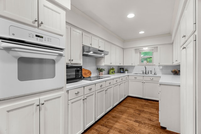 206 S Field St, Prosper, TX 75078 - kitchen with black appliances, under cabinet range hood, white cabinets, backsplash, and ornamental molding
