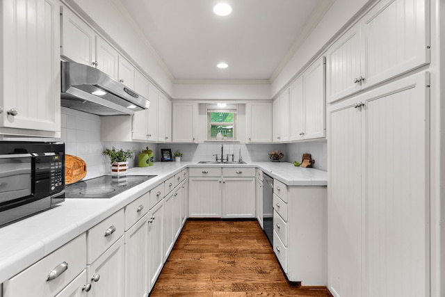 206 S Field St, Prosper, TX 75078 - kitchen with under cabinet range hood, black appliances, white cabinets, dark wood-style floors, and crown molding