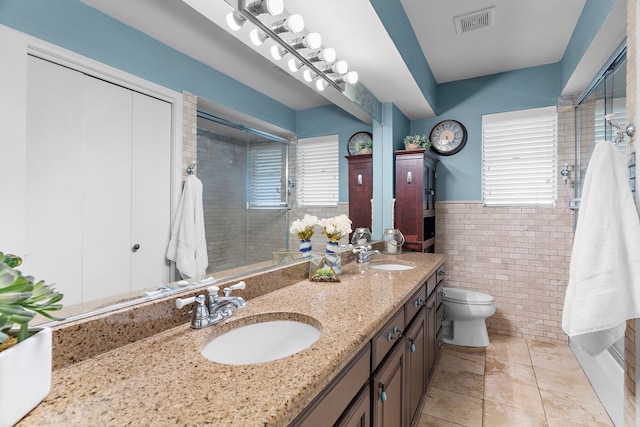 206 S Field St, Prosper, TX 75078 - bathroom featuring healthy amount of natural light, tile walls, a stall shower, double vanity, and wainscoting