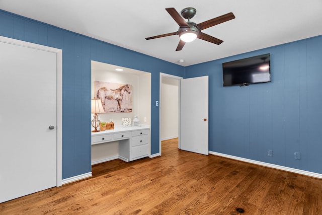 206 S Field St, Prosper, TX 75078 - unfurnished bedroom with wood finished floors, built in study area, and a ceiling fan