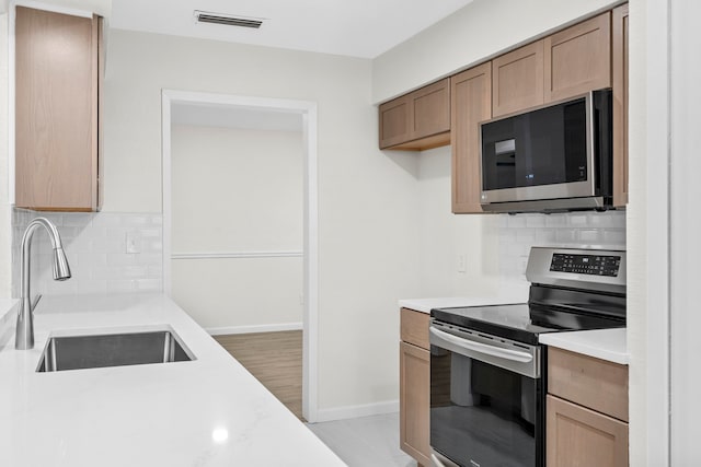 1828 Tracey Cir, Irving, TX 75060 - kitchen with appliances with stainless steel finishes, light countertops, and backsplash