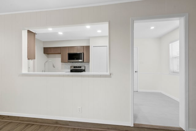 1828 Tracey Cir, Irving, TX 75060 - kitchen with stainless steel microwave, stove, wood finished floors, light countertops, and decorative backsplash