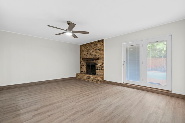 1828 Tracey Cir, Irving, TX 75060 - unfurnished living room with wood finished floors, ceiling fan, and a brick fireplace